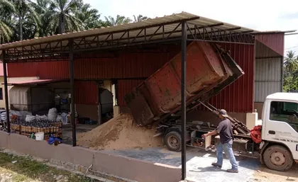 Lori menurunkan habuk kayu di kawasan pemprosesan bongkah.